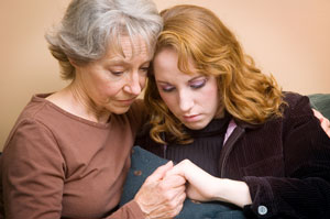 Two ladies, hoding hands.